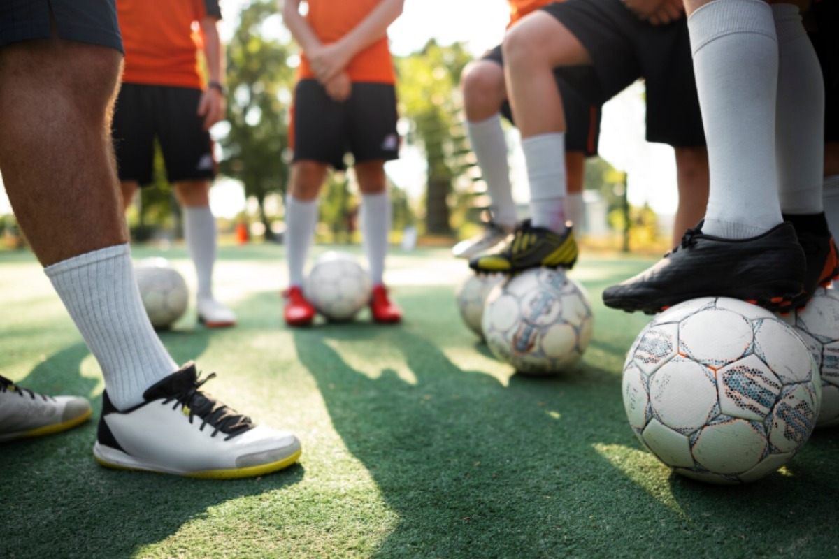 Jugadores y balones de fútbol. Foto: Freepik