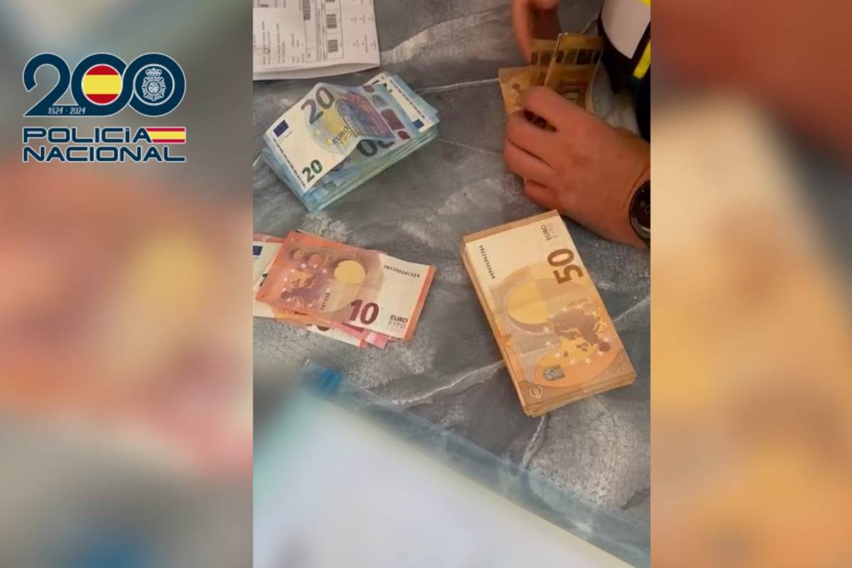 Un agente de la Policía Nacional cuenta varios billetes tras los registros