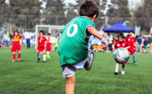 Un niño de las escuelas deportivas de iniciación, jugando al fútbol.