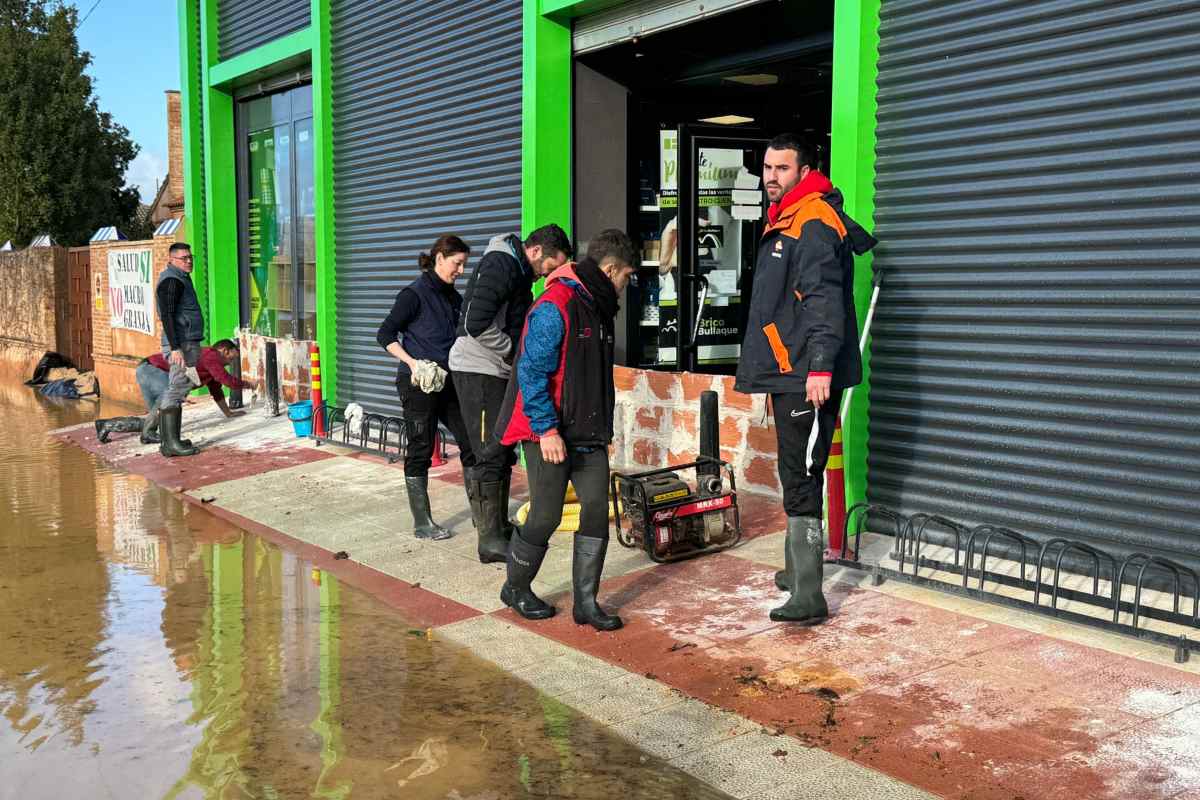 Vecinos del municipio y trabajadores de un negocio haciendo diques de contención ante el temor de nuevas crecidas