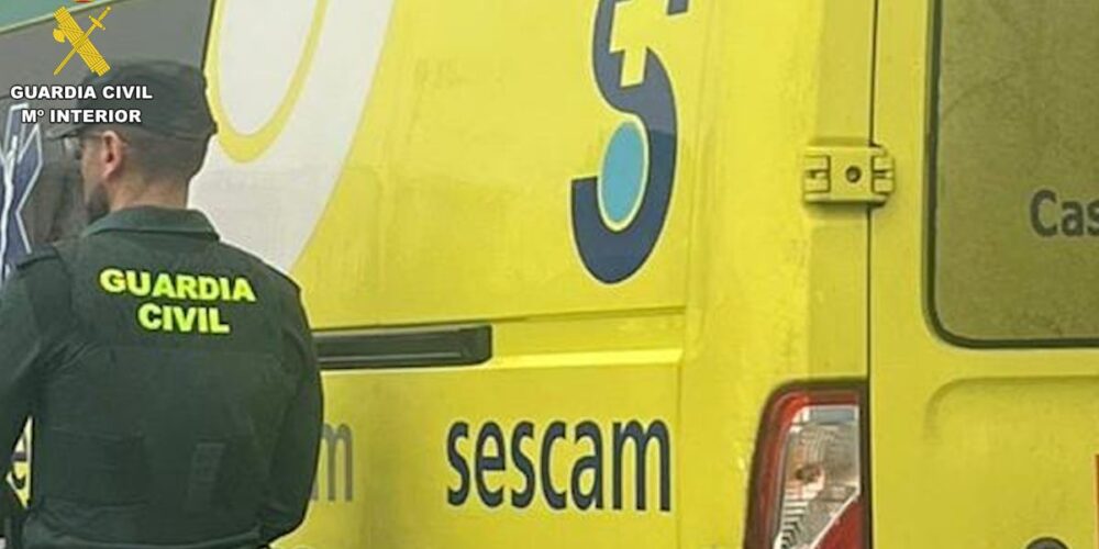 Agente de la Guardia Civil con una ambulancia del Sescam