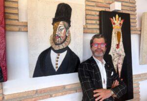 Alberto Romero, junto a dos de sus obras.