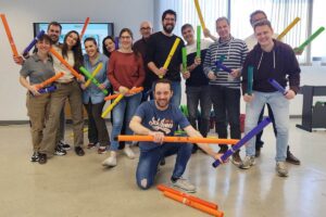 Carlos Alcázar, en el centro de la imagen agachado, realizando uno de sus talleres con un grupo