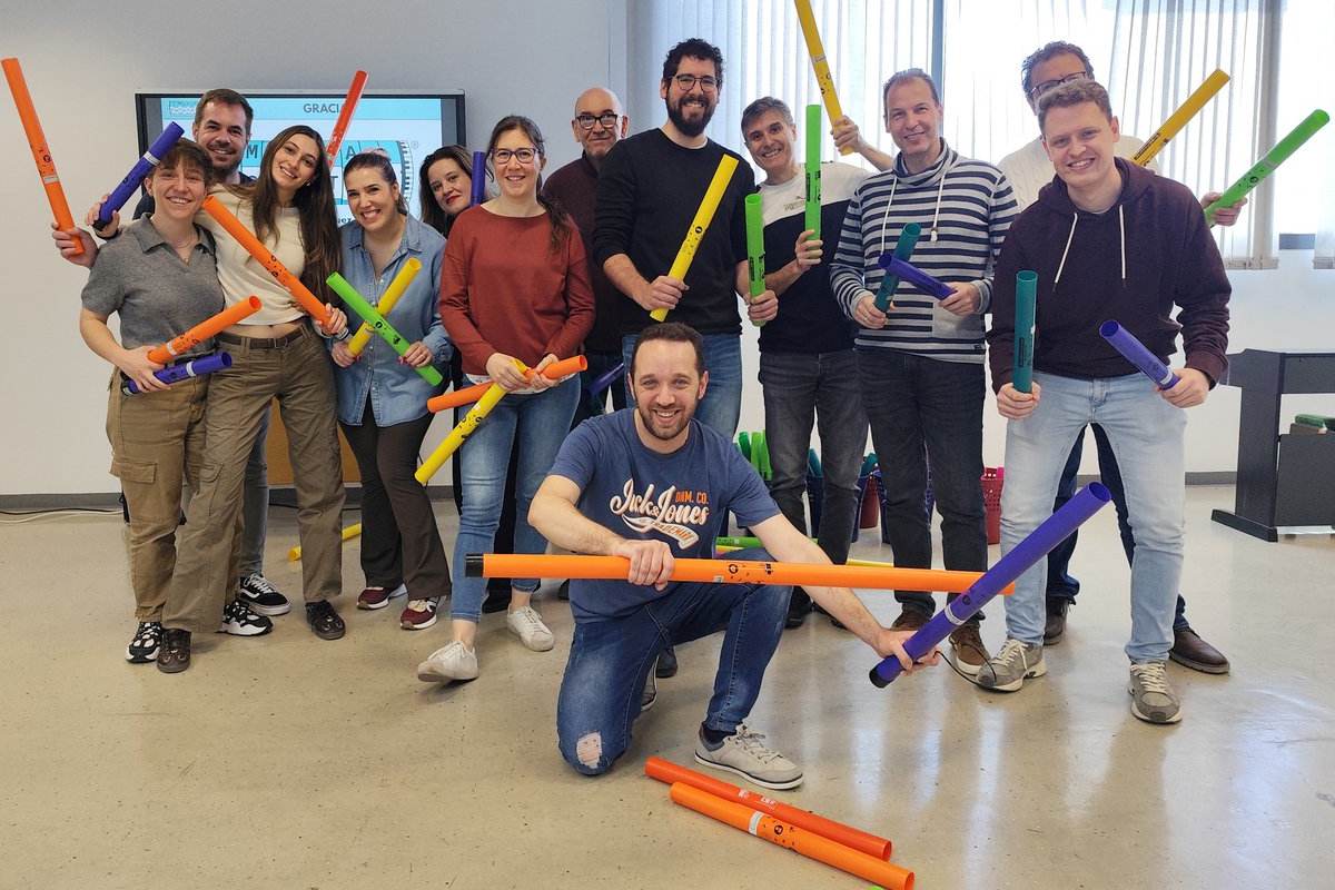 Carlos Alcázar, en el centro de la imagen agachado, realizando uno de sus talleres con un grupo
