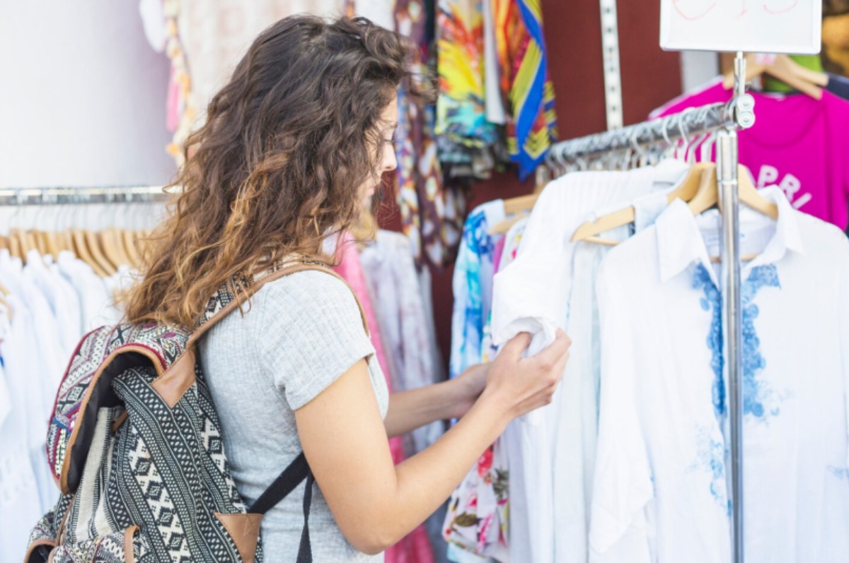 Mujer mirando ropa en un mercadillo. Imagen de archivo