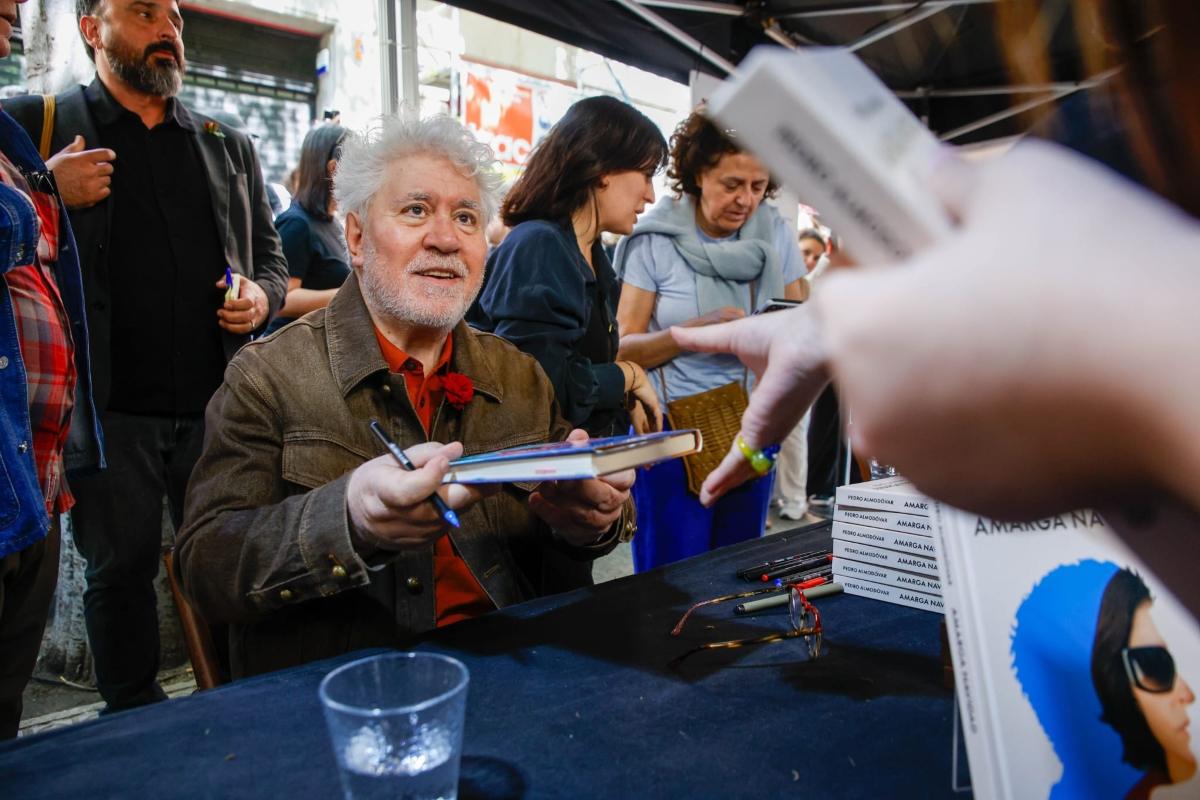 Imagen del director Pedro Almodóvar firmando el guion de su última película