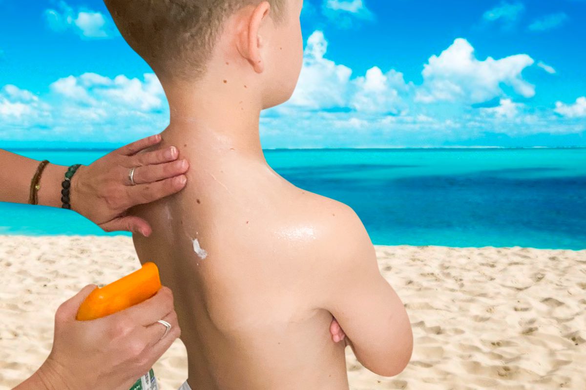 Imagen de una persona echando crema solar a un niño. Foto: Sescam