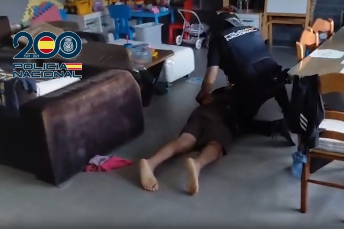 Un agente esposa a uno de los detenidos