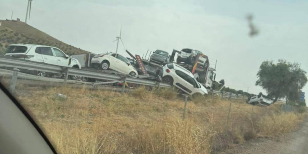 Foto del camión que se salió de la vía, con varios de los coches que portaba sobre aquella.