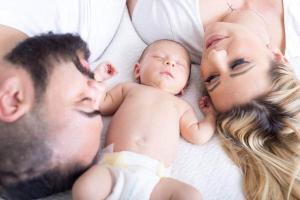Un bebé, entre sus padres.