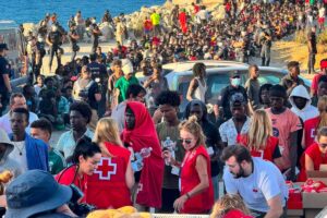 Cruz Roja y Cooperación Sur-Sur reparten alimentos básicos a unos 2.000 migrantes en la Playa del Trampolín (Ceuta)