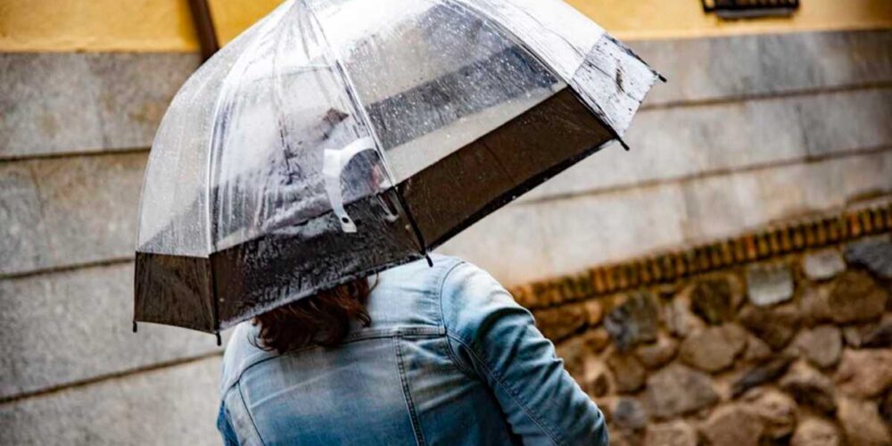 Una mujer se protege de una lluvia débil.